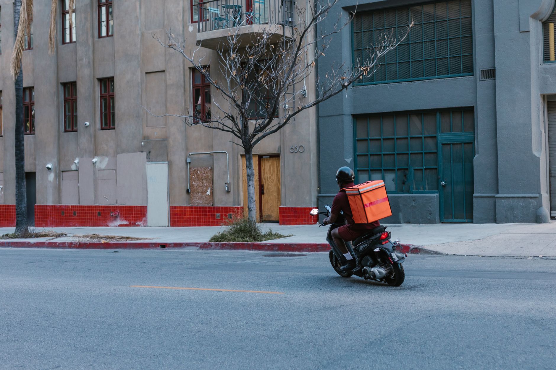Entregador de moto circulando por uma rua da cidade